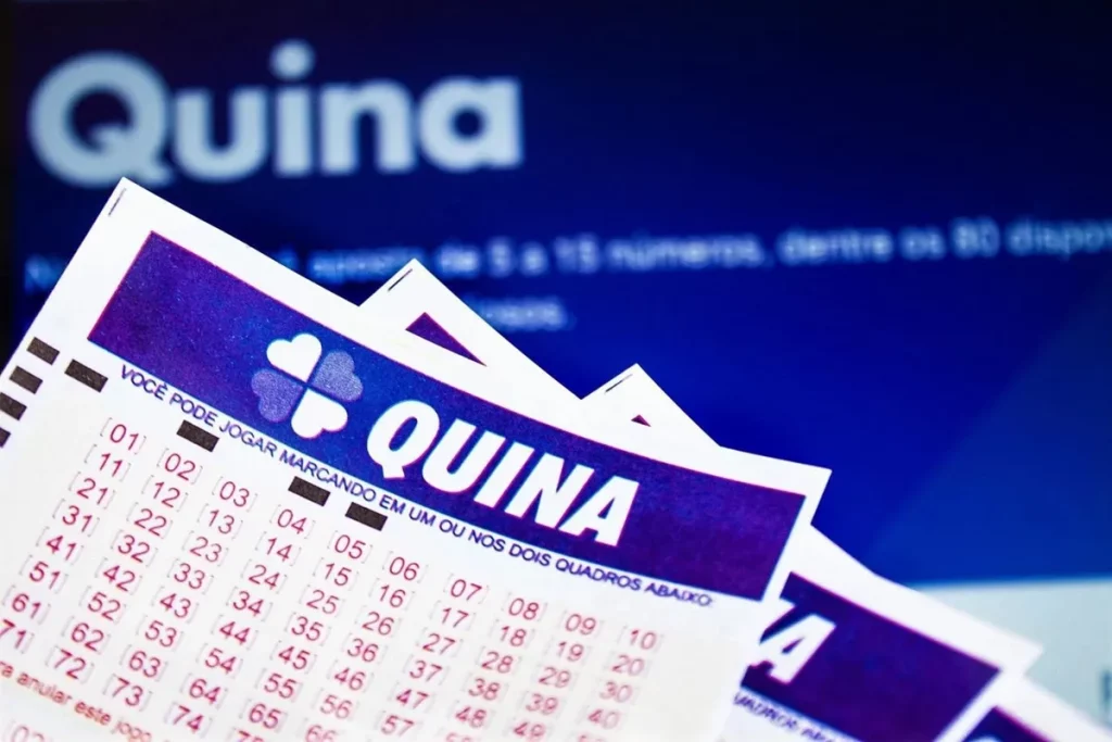 Bilhetes da Quina com números marcados e tela azul ao fundo com informações sobre o sorteio