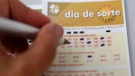 Pessoa marcando os números em um volante do Dia de Sorte com caneta, destacando o processo de aposta