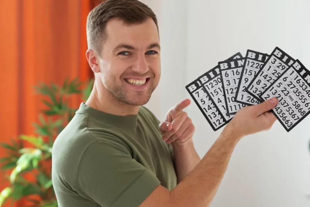 Homem segurando cartelas de aposta e sorrindo