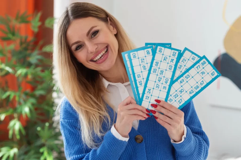 Mulher com cartelas de bingo na mão, sorrindo