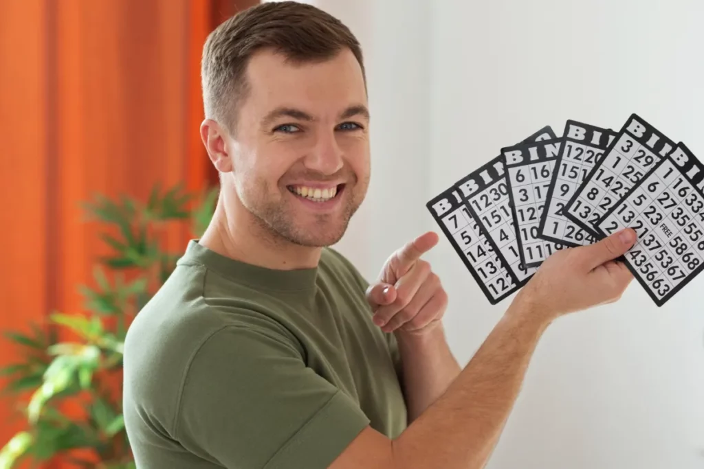 Homem segurando cartelas de bingo
