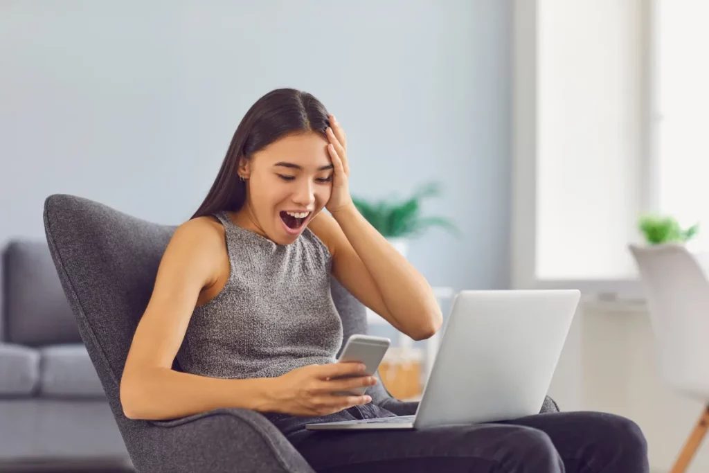 Mulher em seu laptop com expressão de surpresa